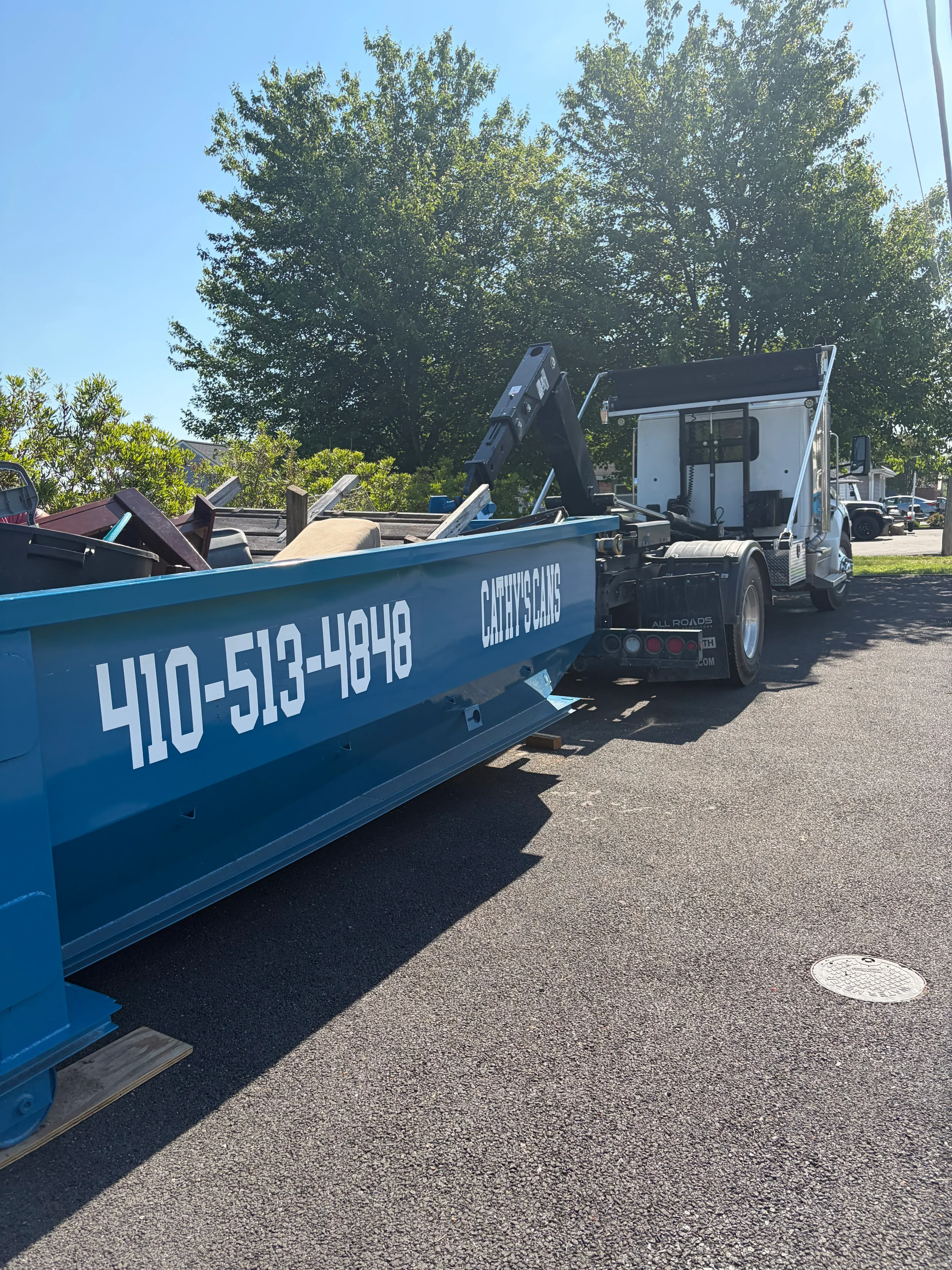 Blue waste collection truck with hydraulic lift system and compactor mechanism