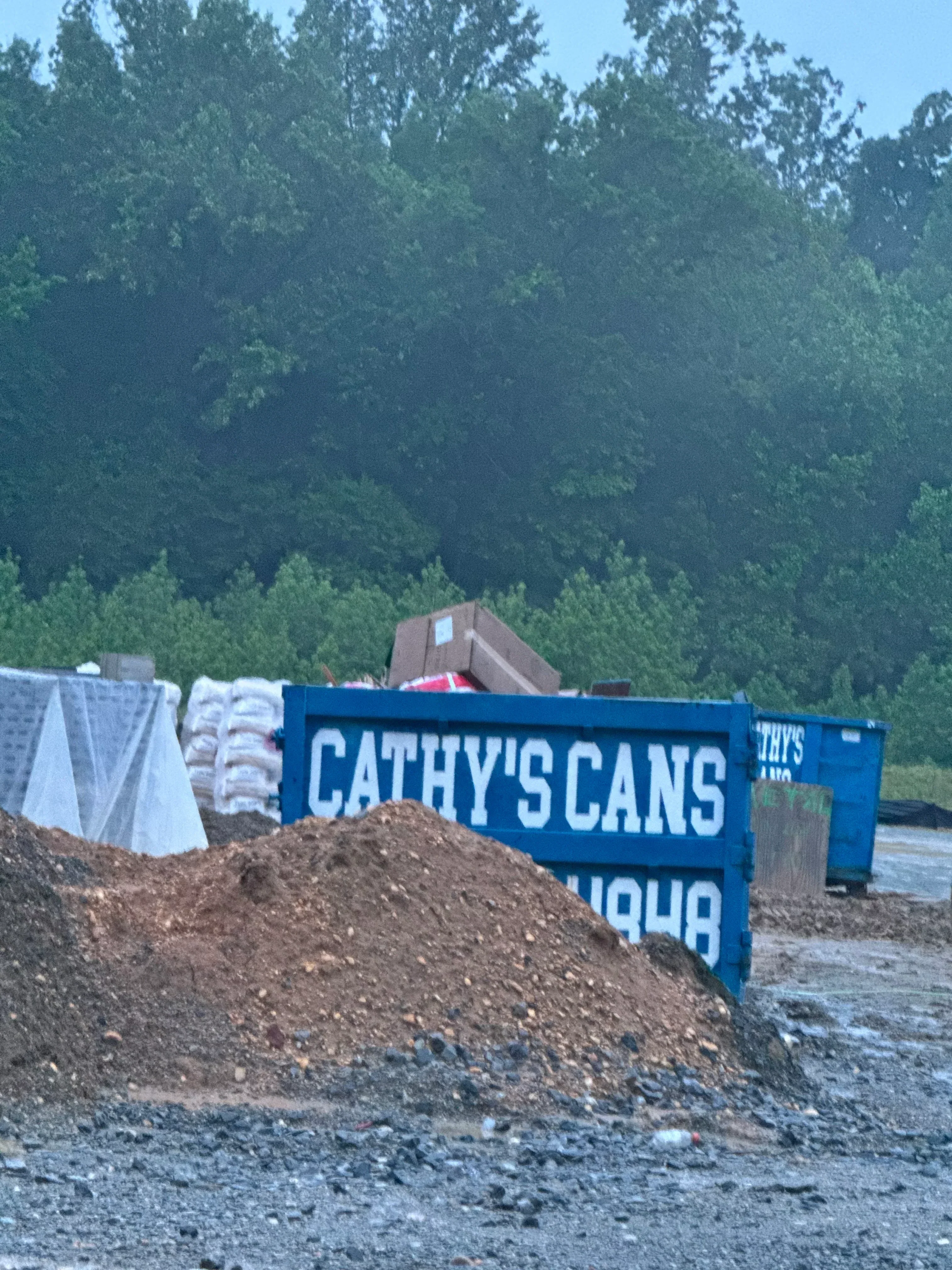 30-yard blue dumpster on gravel driveway next to residential foundation