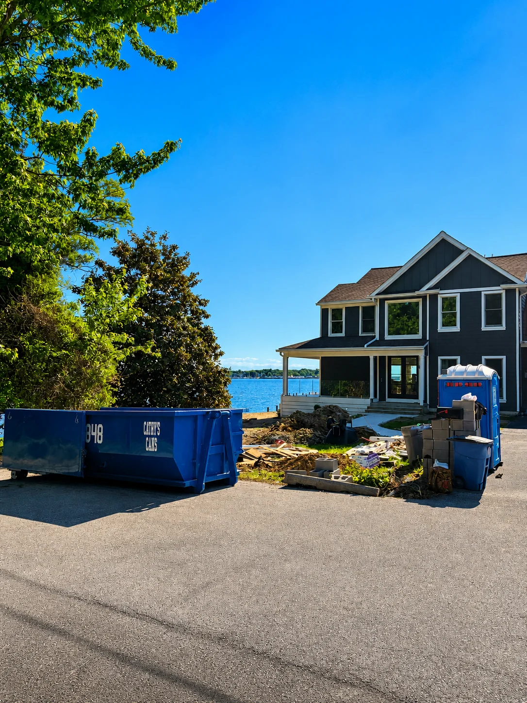 Dumpsters positioned at waterfront home during construction debris removal and renovation cleanup