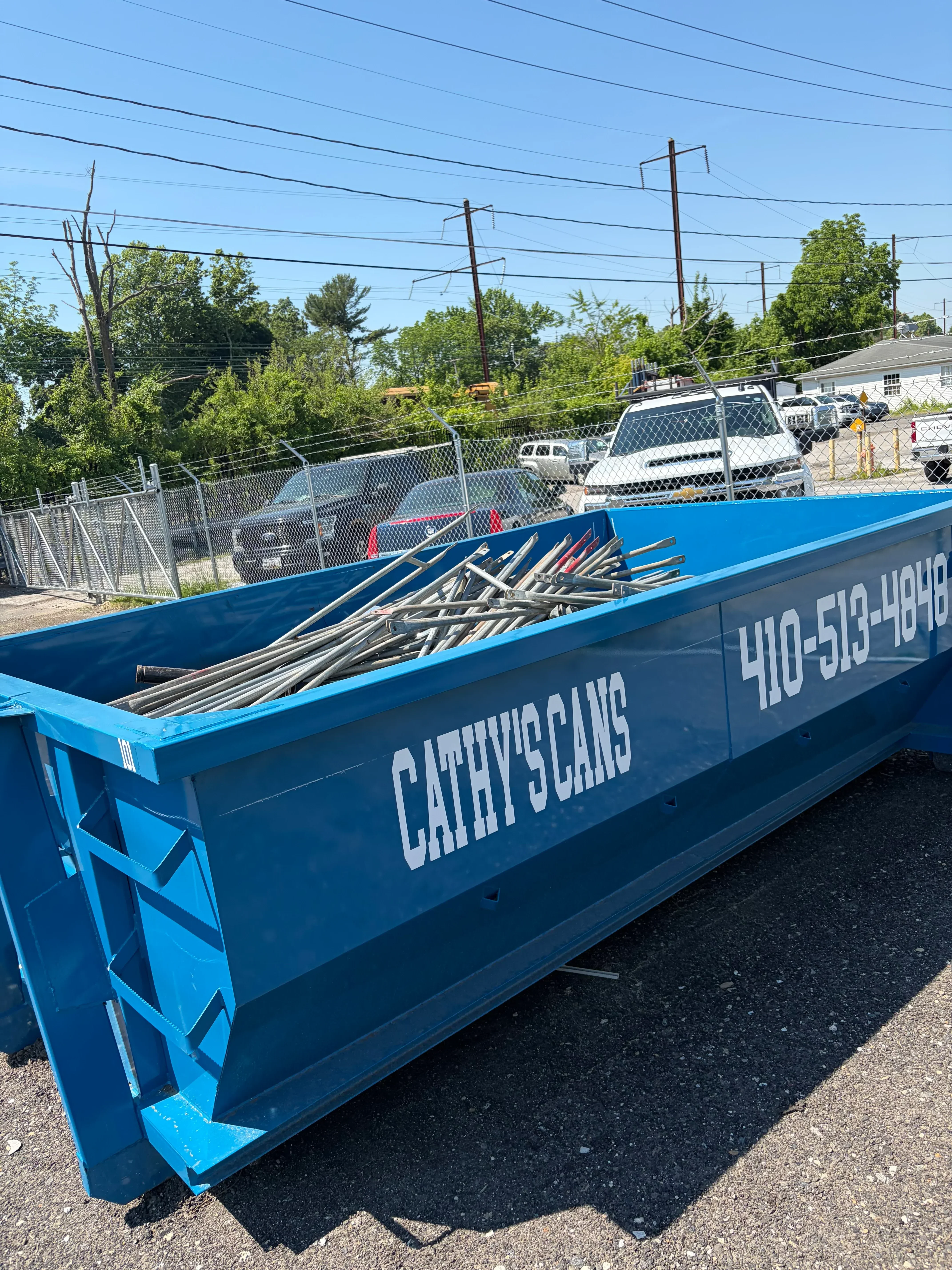 Blue metal dumpster enclosure with mesh panels and geometric design accents