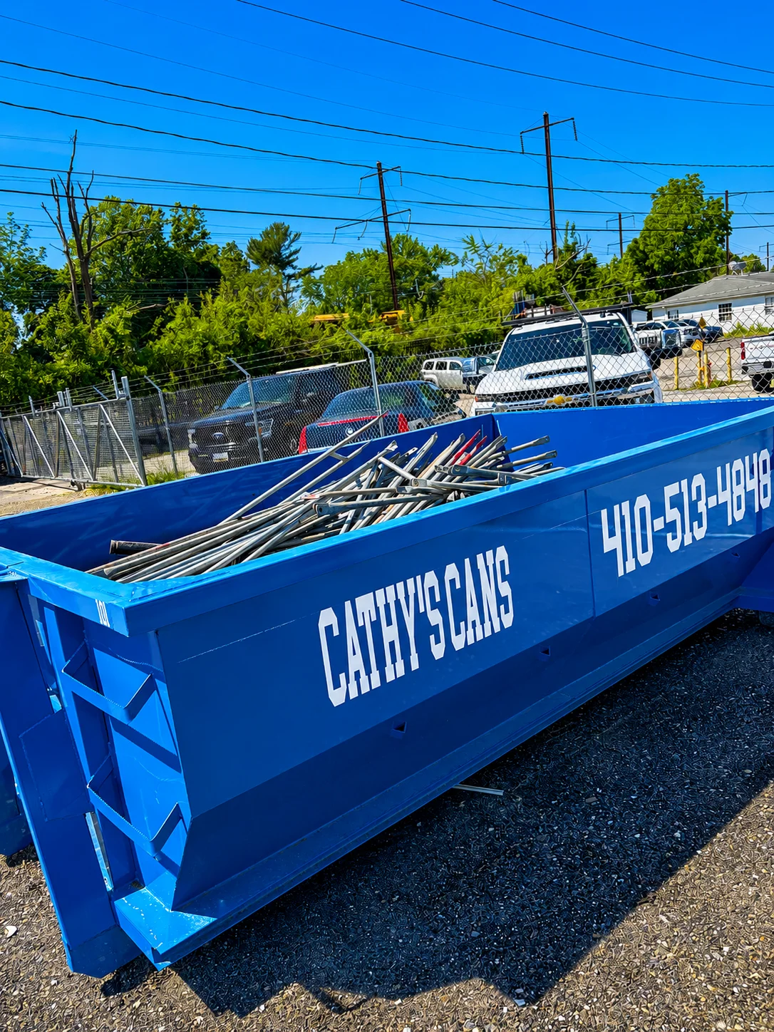 Blue 15-yard dumpster loaded with metal scrap and construction debris